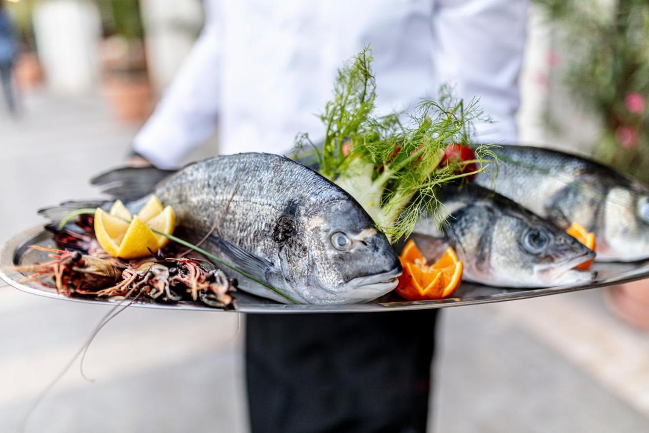 Lighthouse Golf & Spa Hotel Balchik Exterior photo A waiter holding a platter of fish